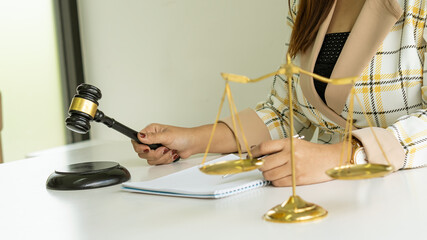 A picture of a gold scale of justice and a woman holding a hammer for the courtroom lawyer on the desk