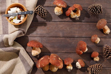 Harvest concept. Wild porcini mushrooms in a handmade wicker basket on a wooden background top view. Flat lay.