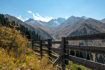 Fototapeta na wymiar landscape in the mountains with wooden fence and blue trekking poles