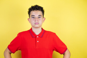 Beautiful teenager boy over isolated yellow background skeptic and nervous, disapproving expression...