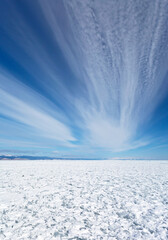 Baikal Lake in winter. View of the snow-covered Small Sea Strait and stratus clouds on the blue sky. Beautiful winter landscape. Ice travel. Natural background