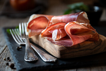 Italian prosciutto or jamon with rosemary, raw ham - obrazy, fototapety, plakaty