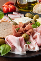 Piatto di prosciutto cotto, salame,guanciale, gorgonzola e grana, antipasti italiani 