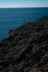 Rocas de la costa con un barco en el fondo