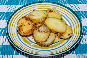 Hot baked potato slices with thin skinned potatoes on a plate. A simple and quick after-work meal for the worker and bachelor. Inexpensive food for poor people and farmers