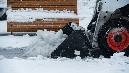 Snow blower removes snow from the sidewalk