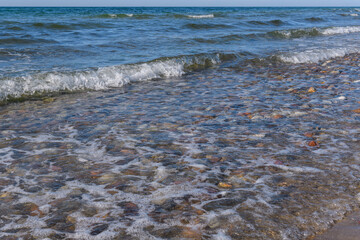 Kiesstrand am Meer mit Wellen und Brandung in Dänemark