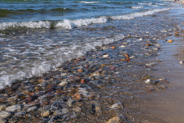 Kiesstrand am Meer mit Wellen und Brandung in Dänemark