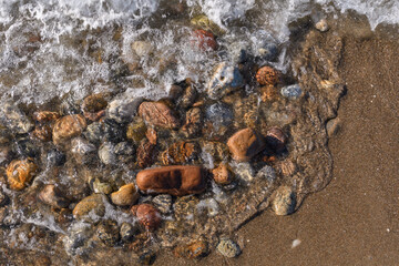 Kiesstrand am Meer mit Wellen und Brandung in Dänemark