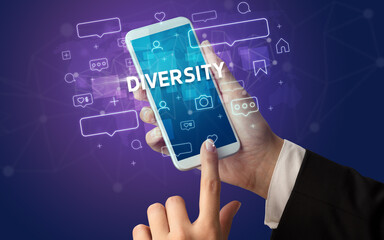 Female hand typing on smartphone with DIVERSITY inscription, social media concept