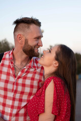 Obraz premium Beautiful guy with a girl walking in the field, a woman in a red dress, a brunette with long hair, a guy in a plaid shirt, love, relationships, couple, husband and wife