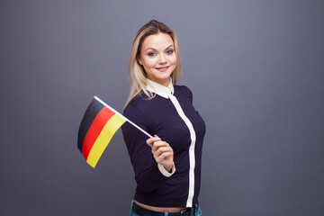 Immigration and the study of foreign languages, concept. A young smiling woman with a Germany flag...