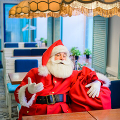 Friendly santa claus in a cafe.