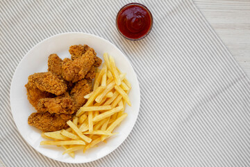 Homemade Crispy Chicken Wings and French Fries with ketchup, top view. Overhead, from above, flat lay. Space for text.