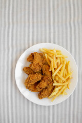Homemade Crispy Chicken Wings and French Fries, overhead view. Top view, from above, flat lay. Space for text.
