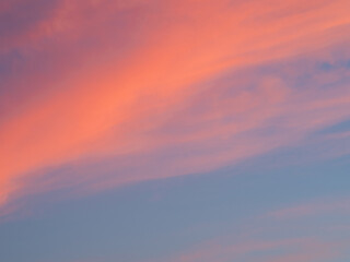 Naklejka na ściany i meble Bright sky illuminated by pink sunset light as background and texture.