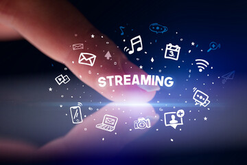 Finger touching tablet with drawn social media icons and STREAMING inscription, social networking concept