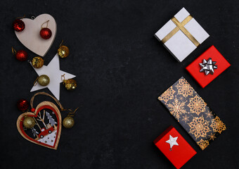 new year festive background, christmas tree wooden toys, red and gold balls, gift boxes with ribbons on black background, top view, flat lay, place for text