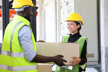 African American and Asian warehouse worker helping each other as teamwork to carry the product...
