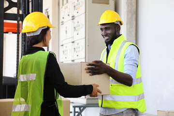 African American and Asian warehouse worker helping each other as teamwork to carry the product package to be ready for shipping