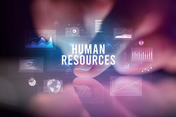 Finger touching tablet with charts and HUMAN RESOURCES inscription, business concept