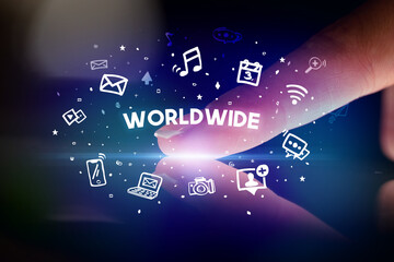 Finger touching tablet with drawn social media icons and WORLDWIDE inscription, social networking concept
