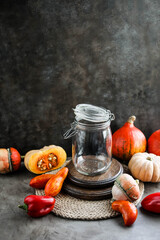 Empty jar on the table with vegetables. Autumn harvest of tomatoes, pumpkins and peppers.