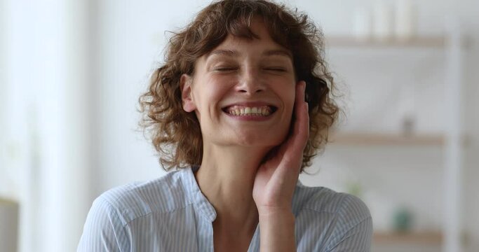 Head shot close up portrait cheerful middle-aged woman standing indoor laughs over joke looking at camera has good mood. Overjoyed female feels carefree enjoy humor or comedy movie anecdote concept