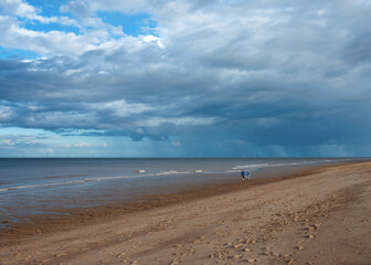 Sand beach, sea and cloudy blue sky in England in sunny day