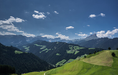Fototapeta premium Alpine meadows and Sass de Putia/Peitlerkofel solitary mountain in the background, as seen from the hiking trail around La Val village, South Tirol, Italy.