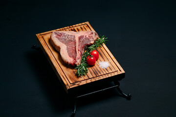 Raw meat steak t-bone on a black background.