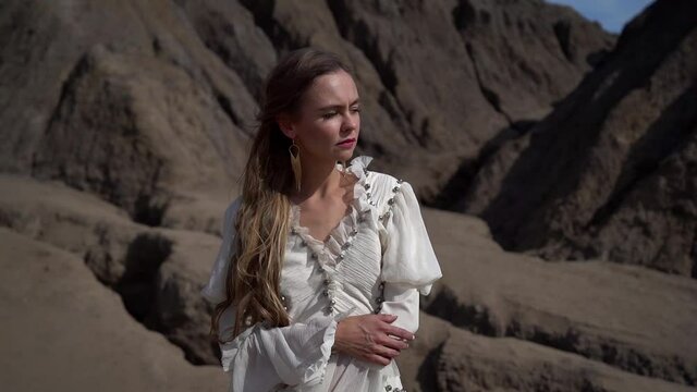 romantic thoughtful woman is walking at nature in desert in summer day, portrait