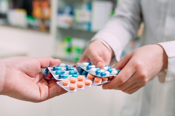 Close up of a girl hands buying pills  in a pharmacy.