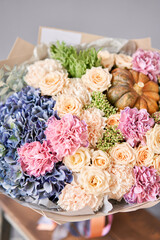 Autumn bouquet of mixed flowers on wooden table. The work of the florist at a flower shop. Fresh cut flower.