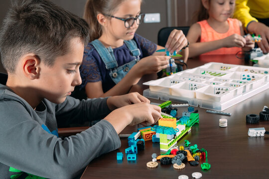 Kids creating robots with teacher. Early development, diy, innovation, modern technology concept.