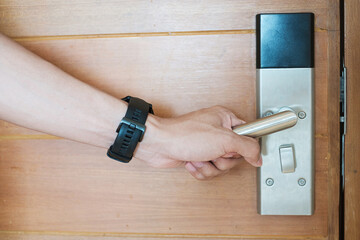 man holding handle of smart digital door lock between open or close the door. Technology,...