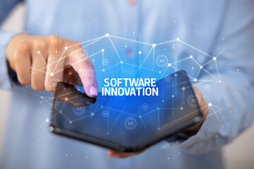 Businessman holding a foldable smartphone with SOFTWARE INNOVATION inscription, new technology concept
