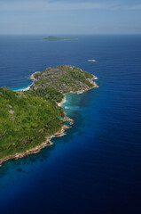 Naklejka na ściany i meble Aerial view of a tropical island with coastline and blue ocean. Félicité Island, La Digue, Seychelles
