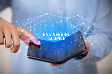 Businessman holding a foldable smartphone with ENGINEERING SCIENCE inscription, new technology concept
