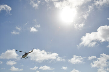 Helicopter on scenic flight with clouds and blue sky in a tropical place