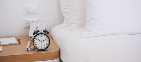 Black Retro alarm clock on table in bedroom at night, sleeping and daily routine concept