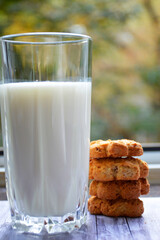 a glass of milk and shortbread cookies for a healthy breakfast on the background of a board with a wooden texture