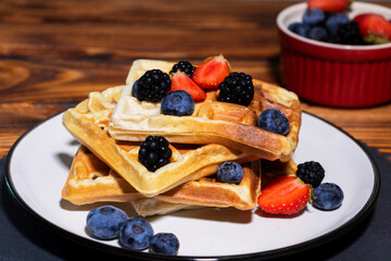 Belgian waffles wit strawberry, blueberry and blackberry. Top view.