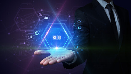 Fototapeta premium Man hand holding BLOG inscription, social media concept