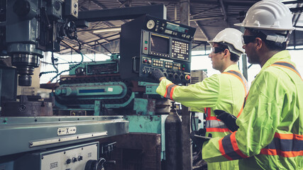 Group of factory workers using machine equipment in factory workshop . Industry and engineering...