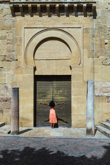 Woman standing on door of old building