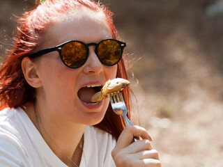 Face of young woman eating baked potato