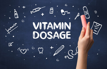 Hand drawing VITAMIN DOSAGE inscription with white chalk on blackboard, medical concept