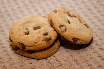 Close up on cookies with dark chocolate chips on a rustic towel. Dessert and pastries