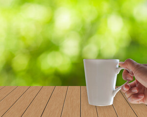 hand holding warm drink  with green background